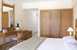 Кровать или кровати в номере Mitsis Petit Palais Beach Hotel